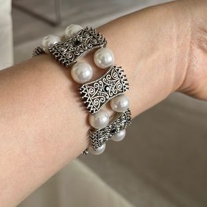 A unique design has peals, onyx, silver bracelet.